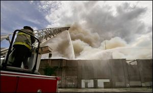 Firefighters pour water onto the three-story complex, which had been vacant for years. Firefighters did not enter the complex because it was considered too dangerous. 