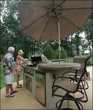 Rudy and Michellle Strom cook on the TEC grill on their patio.
