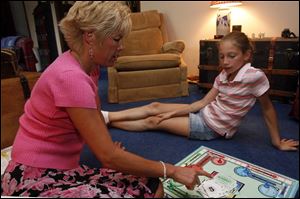 Cindy Hadsell plays a board game with her daughter, Lauren, 10, who will be starting fifth grade this fall.