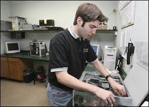 Adam Young, one of four technicians at Mann Technologies, services a computer at the business in Millbury. The company has found its east-of-the-Maumee location to be a plus.