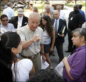 Carty Finkbeiner talks with residents at Page and Locust. The city tore down a house on Locust earlier yesterday.