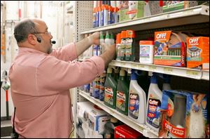 Doug Janney restocks the shelves with anti-mosquito products at Janney's Ace hardware in West Toledo.