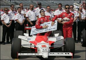 Sam Hornish Jr. has the check for winning the pole position for the Firestone Indy 400 at MIS yesterday, but the name on the check belongs to his teammate, Helio Castroneves, right. Hornish will start in the No. 2 position.