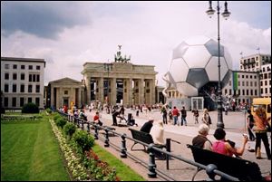 A building-size soccer ball - part of the hubbub surrounding the recently completed World Cup competition - flanks Berlin's famous Brandenberg Gate, a momument to peace where Ronald Regan implored the Soviet Union's Mikhail Gorbachev to 'tear down this wall.'