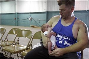 Before the Strongman Competition got under way yesterday, Alan Waterfield spends a few moments with his infant daughter, Karah.