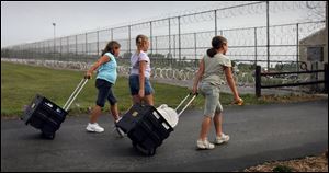 From left, Appleseed Ridge Girl Scouts Jami Lee, 7, Natasha Sawyer, 9, and Julie Lee, 9, leave the Allen County Correctional Institution.