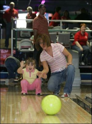 ON A ROLL: Melanie Whipple, 4, gets a hand from mom Cori Whipple at Ducat Imperial Lanes for the shelter.