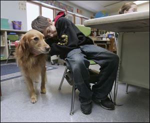 Fourth-grader Joseph Ford grabs a quick hug. Allie will be recognized on Saturday at the fair as one of the state's outstanding animals.