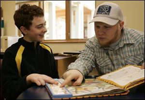 Reed Mayberry, left, who is part of an autism program at Bittersweet Farms, works with Scott Biddle. 