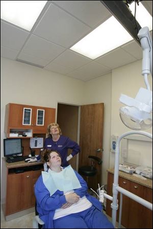 Jeanie Holzscheiter uses a wireless keyboard to change pictures for Cassanaundra Pitney.
