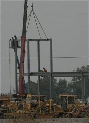 Ironworkers erect the frame for the first building at the Shops at Fallen Timbers center, expected to have 80 shops. 
