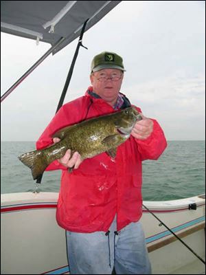 Toledo angler Dan Tucker hefts a 19-inch, 4 1/2-pound smallmouth bass taken in Lake Erie while fishing for yellow perch.