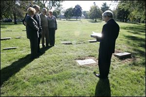 Bonnie and Ken Dickson, left, and Jack and Barbara Kennedy listen as the Rev. Robert Wilhelm
reconsecrates the grave of Louise Bell, slain during Toledo s turbulent Prohibition days.
