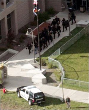 Members of a SWAT team exit the Platte Valley High School in Bailey, Colo.