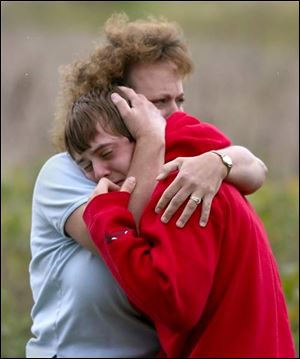 Linda Young hugs son Dakota, a junior at Woodmore High School, as they grieve the loss of Todd Hatch, also a Woodmore junior.