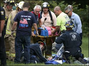 Rescue workers assist two of the teenagers who were injured in the crash near Woodville. 
