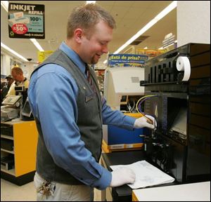 Andrew Dauer, assistant manager of the Monroe Street Walgreens, refills a cartridge at the recently installed machine. 