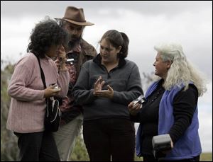 Lidia Senra of Spain, left, and Jean Cabaret of France listen as Lis Maguire of Food & Water Watch, a Washington-based activist group, interprets for Lynn Henning, a Michigan farmer.