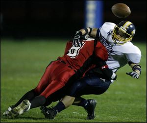 Cardinal Stritch's Nick Baker levels Toledo Christian's Ray Dominguez, preventing him from catching the ball.