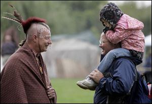 American Indian re-enactor Clarence Nieset talks with Eric Bell and his daughter, Carissa Bell, 4, at Buttonwood Park.