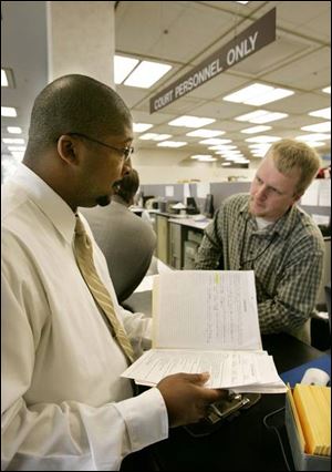 Agent Eric Hill, left, is aided by Deputy Clerk Lenny Tomanski at Toledo Municipal Court. 