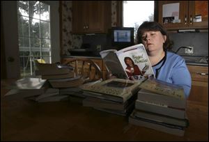 Dawn Trumbull of South Toledo looks through books she's swapping on the Internet.