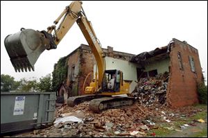 Equipment operator Scott Apple demolishes a nuisance property on Sugar St. in Milton Center.
