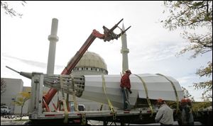 The fallen minaret at the Islamic Center of Greater Toledo is prepared for removal. Two vehicles were damaged when it fell.