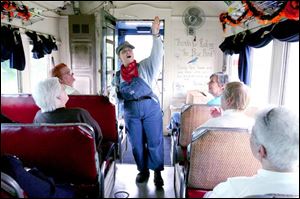 Volunteer Karen Oles tells passengers about the interior of the tourist train.