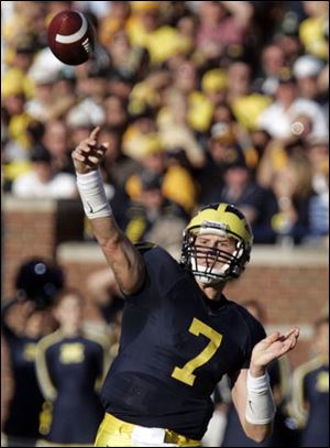 Chad Henne lofts a touchdown pass for Michigan against Michigan State. He threw for 140 yards and three TDs.