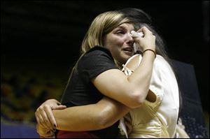 UT student Lora Sarich, left, is comforted by Brie Henning, a UT swimmer, during yesterday's memorial service in Savage Hall. 