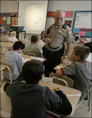 Officer Bill Schultz talks with John C. Roberts Middle School sixth graders.