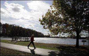Shelly Ferris of Toledo strides through Olander Park. The park system is asking voters to renew a 0.5-mill levy next month.
