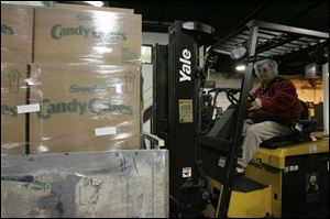 Bonnie Dangler loads cases onto trucks.