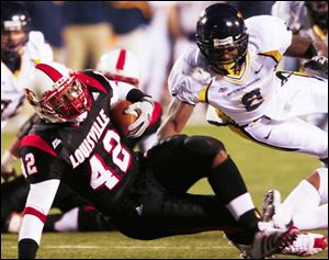 Louisville running back Anthony Allen gets past West Virginia s Quinton Andrews in the first half last night.
