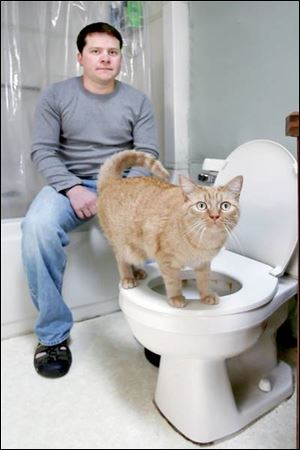 Corey Wisniewski with his cat, Wombat. Mr. Wisniewski s video of Wombat using the toilet has had more than
140,000 viewers on the Metacafe Web site, earning the Point Place resident $700.