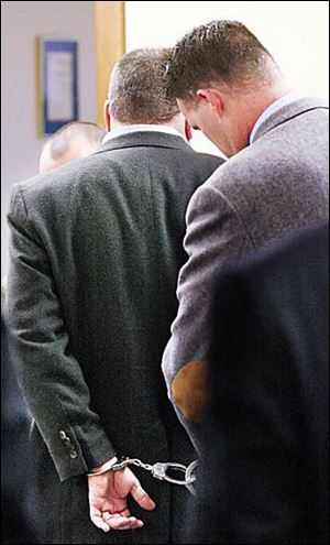 A federal marshal handcuffs Tom Noe after a jury found the former rare-coin dealer and big-time GOP donor guilty.