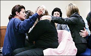 Showing no emotion as the jury verdict was read in court, Tom Noe's wife, Bernadette, moves to comfort members of their family, including daughters, a sister, and brother-in-law.