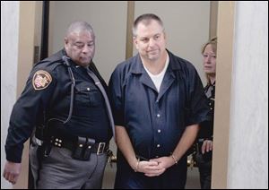 A handcuffed Tom Noe is led into court for his sentencing.