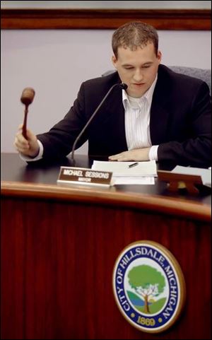 Mayor Michael Sessions, 19, wields his gavel to close a recent session of City Council in Hillsdale.