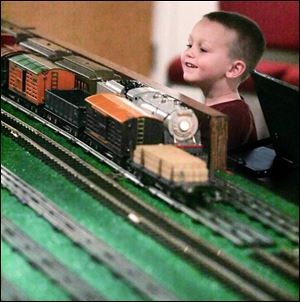 Carson Silardi, 3, of Tiffi n keeps his eyes on the toy trains that run each Christmas at the presidential library in Fremont.