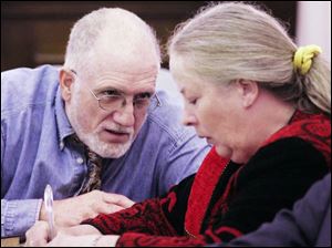 Michael Gravelle speaks with his wife, Sharen, during the opening of their criminal trial. 