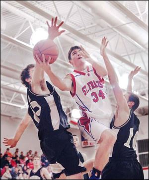 St. Francis' Nick Meinert knifes between Perrysburg's Glenn Empie, left, and Ricky Heber. Meinert scored 22 points.