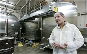 Behind Dwight Stoller, CEO of Golden Heritage Foods,
are tanks of honey being fed to bottling line. 


