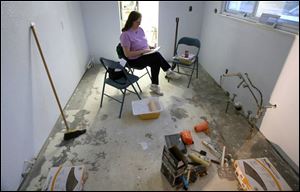 Margaret Gillis sits in her under-repair kitchen, reading a book as she waits for her husband, Albert, to come home from work.
He took on extra work as a security officer to help pay for materials, even though the Delmonte Drive house was insured.