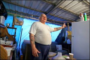 Albert Gillis, 70, who is slowly rebuilding his Delmonte Drive home, slept in the tarp-covered back porch for 3 1/2 months.