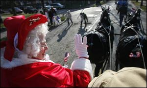 Joy Perry - in her annual role as Mrs. Santa Claus - waves to the crowd as grand marshal of East Toledo's Christmas parade. 