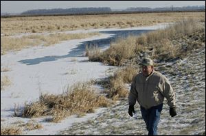 Fulton County farmer Colenzo Short surveys some of the 96 acres of wetland he preserved on his property near Fayette. He is being paid to capture greenhouse gases in the soil.