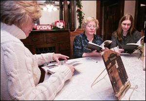 Authors Gaye Gindy, left, and Trini Wenninger examine copies of their book, 'Sylvania,' at a book signing last week in Sylvania.