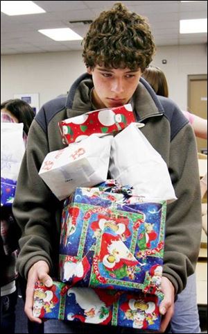Sophomore Andrew Walker balances a stack of holiday presents while waiting to box them up at Springfield High School.